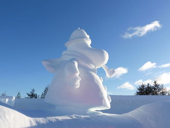 Low angle view of statue against sky during winter