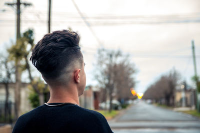 Rear view of man looking at camera