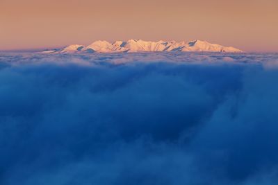 Aerial view of snowcapped mountain against dramatic sky