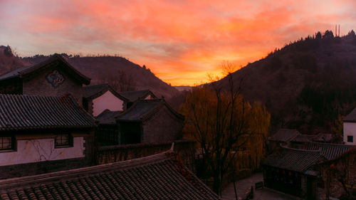 Houses and buildings against sky at sunset