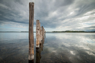 Pier on sea against cloudy sky