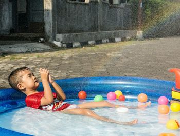 Cheerful boy sitting in pool