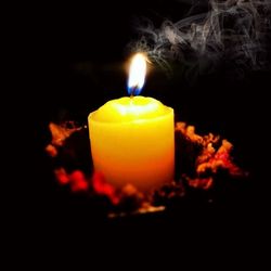 Close-up of lit candle in dark room