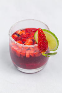Close-up of strawberries on glass table against white background