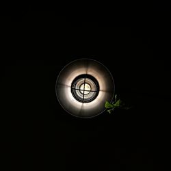 Close-up of illuminated light bulb against black background