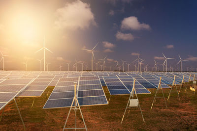 Wind turbines on field against sky