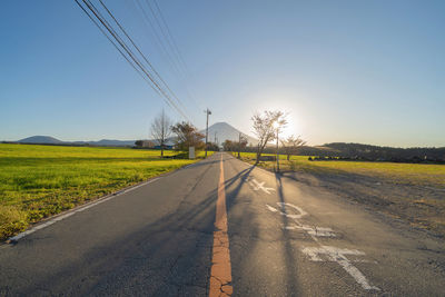 Road amidst field against sky