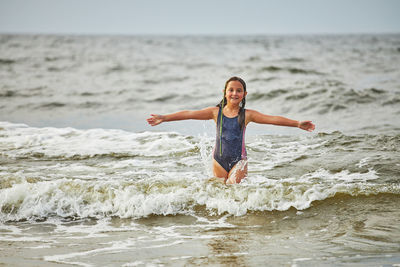 Full length of young woman standing at beach