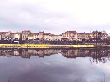 Reflection of buildings in river against sky