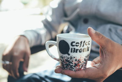 Close-up of man holding coffee cup