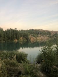 Scenic view of lake against sky at sunset