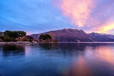 Scenic view of lake by mountains against sky