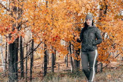 Portrait of smiling man standing by trees during autumn