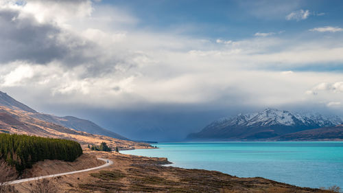 Mount cook road alongside lake pukaki with snow capped southern alps in winter evening light. 