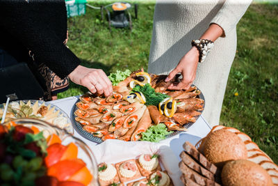 Midsection of woman holding pizza on table