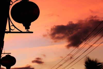 Low angle view of silhouette electricity pylon against sky during sunset