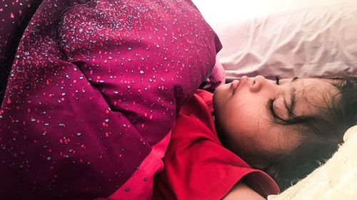 Close-up of baby sleeping on bed