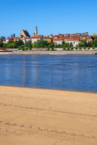 View of river and buildings against blue sky