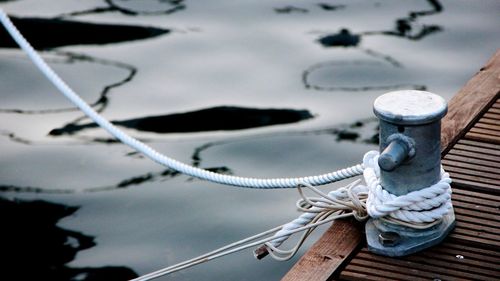 Close-up of rope tied to boat moored at harbor