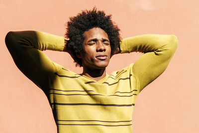 Portrait of young man standing against wall