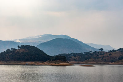 Scenic view of sea and mountains against sky