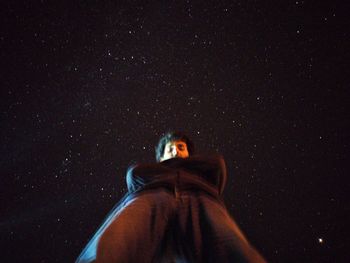 Portrait of woman standing against sky at night