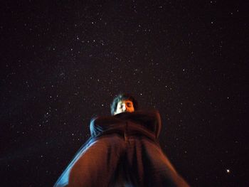 Portrait of man standing against sky at night