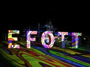 Illuminated amusement park ride at night