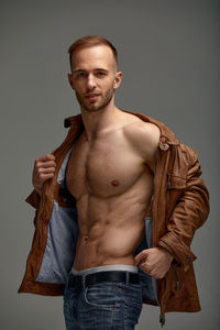 Portrait of young man standing against wall