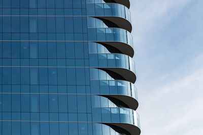 Low angle view of modern building against blue sky