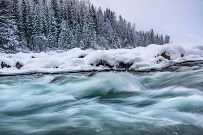 Frozen river flowing during winter