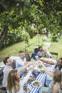 Rear view of people sitting in a yard