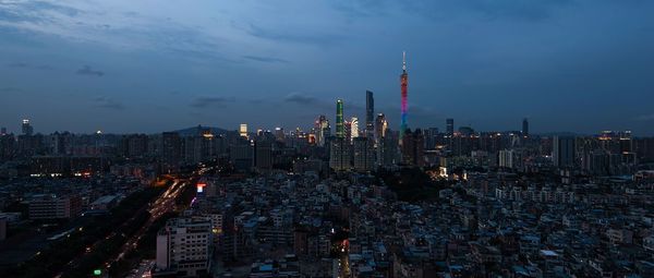 Aerial view of illuminated buildings in city against sky