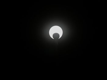 Low angle view of illuminated lamp against dark sky