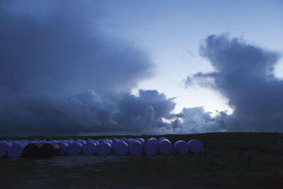 Hay bales on field against sky