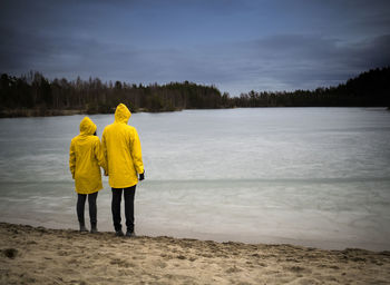 Rear view of couple standing at frozen sea