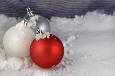 Christmas ornaments on snow dusted background with copy space