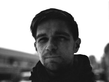 Close-up portrait of young man against sky