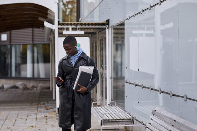 Young man standing in front of modern building