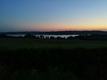 Scenic view of field against clear sky during sunset