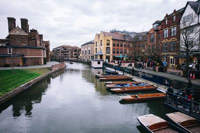 Canal amidst buildings in city against sky