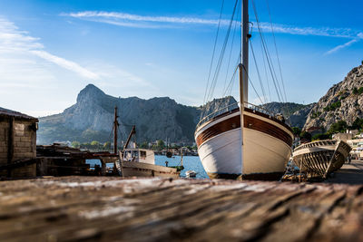 Sailboats moored on shore against sky