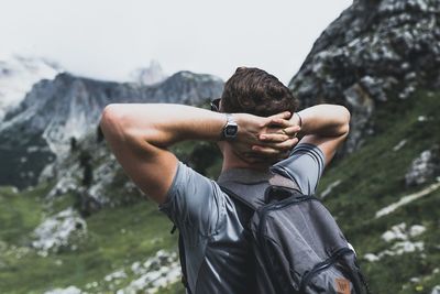 Midsection of man using mobile phone against sky