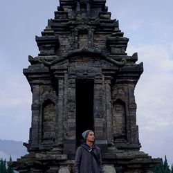 Low angle view of man standing against historic temple during sunset