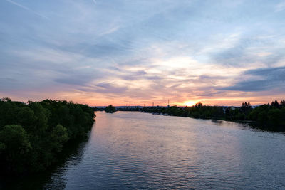 Scenic view of river against sky at sunset