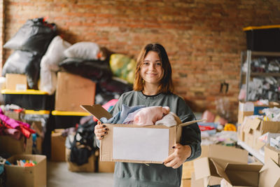 Volunteer teengirl preparing donation boxes for people.