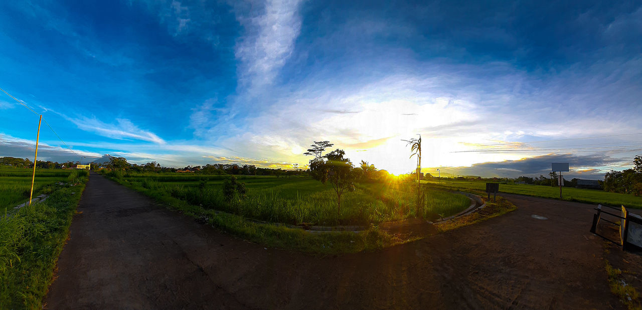 sky, cloud, landscape, environment, sunlight, road, morning, nature, horizon, rural scene, transportation, land, plant, dusk, scenics - nature, beauty in nature, blue, agriculture, field, rural area, no people, outdoors, light, panoramic, reflection, travel, grass, sun, dirt road, tree, tranquility, farm, city, street, hill