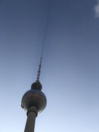 Berlin tv tower at alexanderplatz throws a shadow into bright blue sky