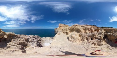 Rock formations on beach against blue sky