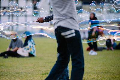 Man standing by bubbles at park